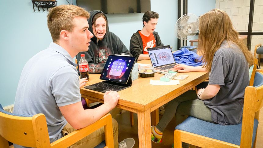 students laugh and study together in group space