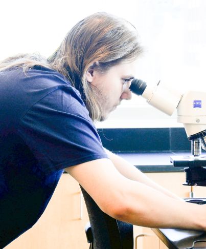 student looks through microsope